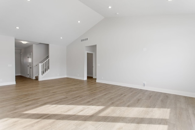 unfurnished living room with high vaulted ceiling and light hardwood / wood-style flooring