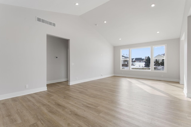 spare room featuring vaulted ceiling and light wood-type flooring