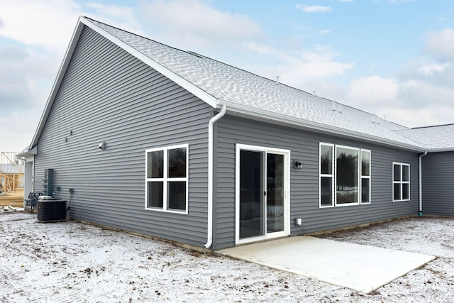 snow covered property featuring cooling unit and a patio