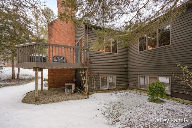 snow covered property with central AC unit