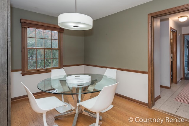dining room with baseboards and light wood-style flooring
