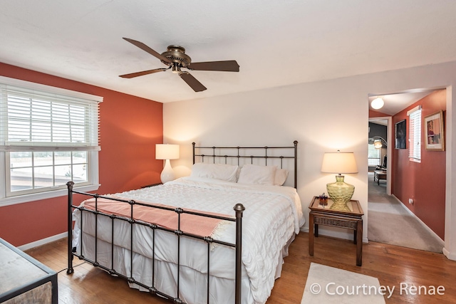 bedroom featuring ceiling fan, baseboards, and wood finished floors