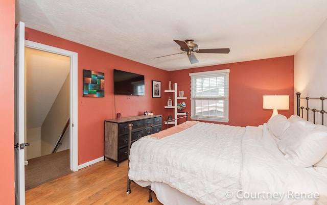 bedroom with ceiling fan, baseboards, and light wood-style floors
