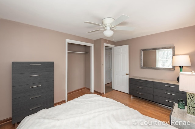 bedroom with ceiling fan, baseboards, wood finished floors, and a closet