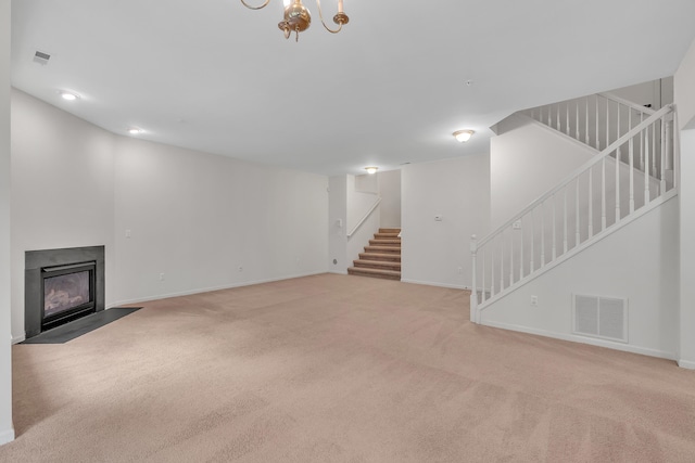 unfurnished living room with an inviting chandelier and light colored carpet