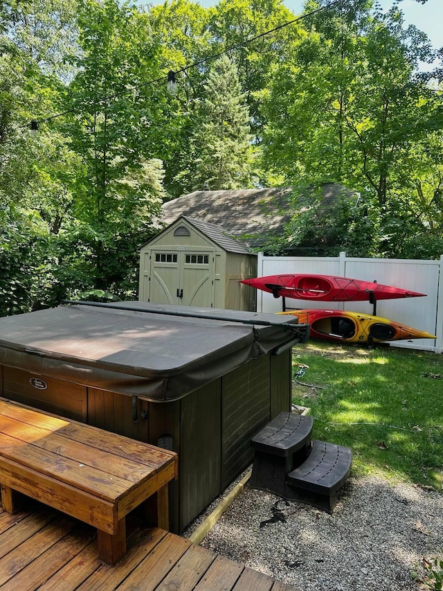 wooden terrace featuring a storage unit and a hot tub