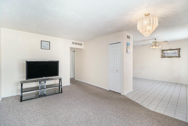 unfurnished living room featuring ceiling fan, light carpet, and a textured ceiling