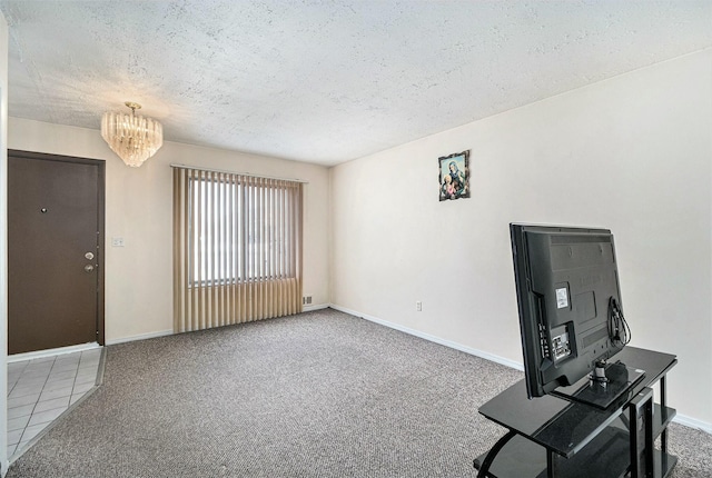 interior space featuring a notable chandelier, carpet floors, and a textured ceiling