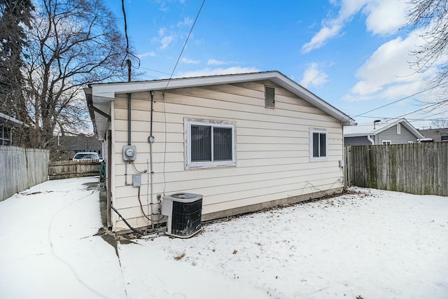 snow covered property with central AC