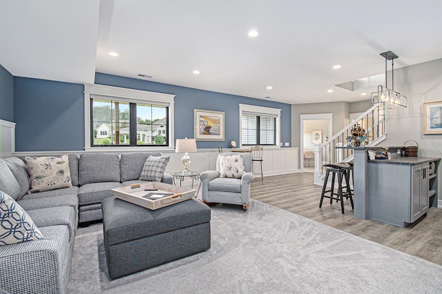 living area with stairs, light wood finished floors, visible vents, and recessed lighting