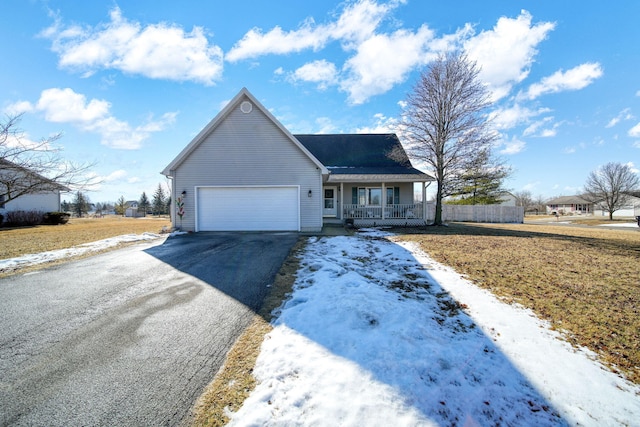 view of front of home featuring covered porch, aphalt driveway, an attached garage, and fence