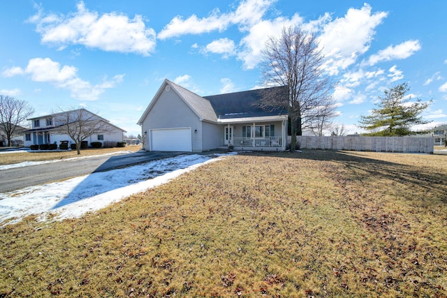 single story home featuring driveway, a garage, fence, and a front lawn