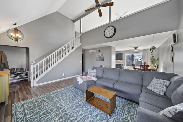 living room featuring high vaulted ceiling, ceiling fan with notable chandelier, dark wood-style flooring, visible vents, and stairs