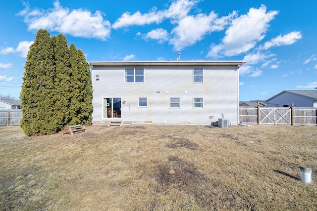 back of house featuring a fenced backyard, central AC, a gate, and a lawn