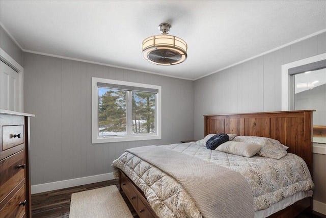 bedroom with crown molding, dark wood finished floors, and baseboards