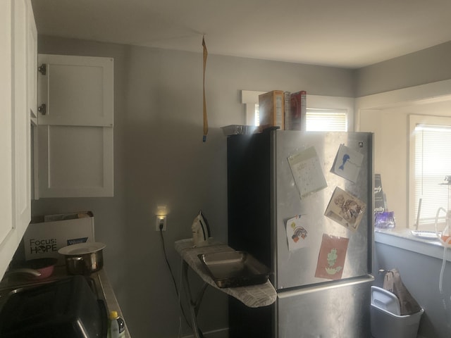 kitchen featuring white cabinetry and stainless steel fridge