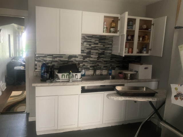 kitchen with sink, white cabinets, stainless steel refrigerator, and decorative backsplash