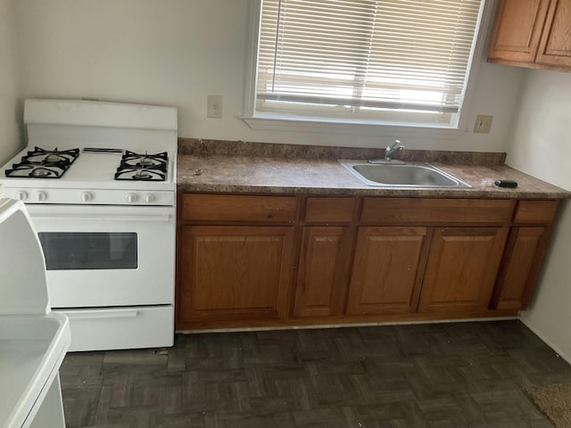 kitchen with sink, white range with gas cooktop, and dark parquet floors