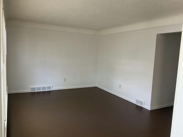 unfurnished room with a textured ceiling