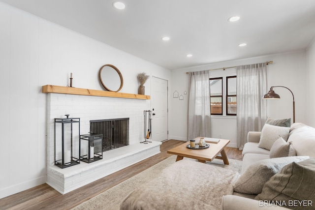 living room with wood-type flooring and a fireplace