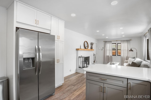 kitchen featuring gray cabinetry, white cabinetry, stainless steel fridge with ice dispenser, and hardwood / wood-style flooring