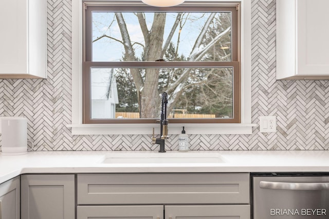 kitchen with sink, stainless steel dishwasher, tasteful backsplash, and a wealth of natural light