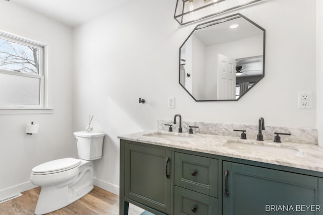 bathroom featuring toilet, hardwood / wood-style flooring, ceiling fan, and vanity