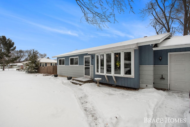 snow covered property with a garage