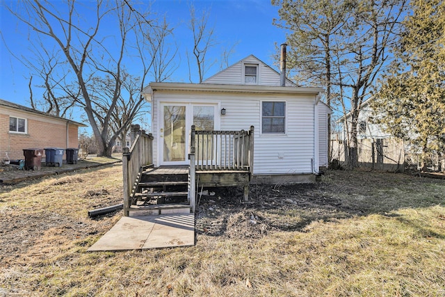 rear view of house featuring a wooden deck and fence