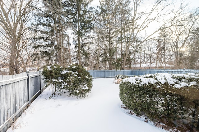 yard layered in snow with a fenced backyard