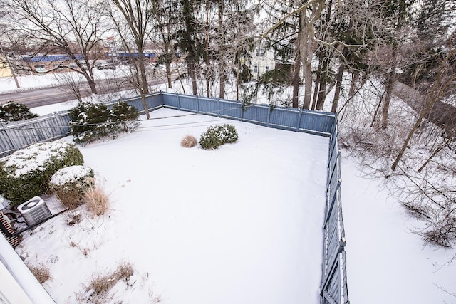 yard covered in snow with central AC unit and fence