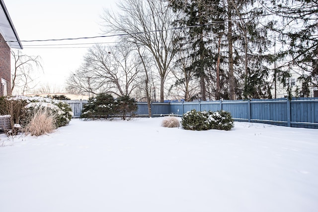 yard covered in snow with a fenced backyard