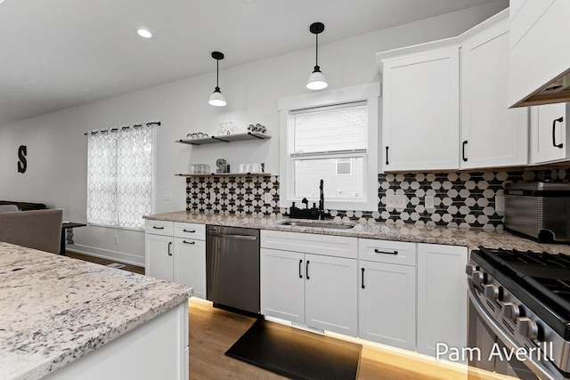 kitchen featuring pendant lighting, sink, black dishwasher, white cabinets, and decorative backsplash