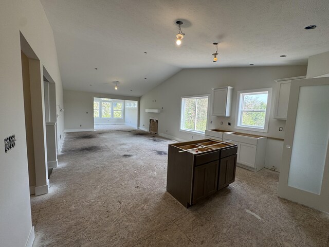 275 Hickory Valley Dr, Kalamazoo, MI 49009 - kitchen featuring white cabinetry, baseboards, light carpet, and lofted ceiling