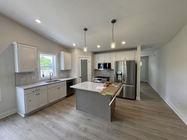 275 Hickory Valley Dr, Kalamazoo, MI 49009 - kitchen with appliances with stainless steel finishes, a sink, decorative backsplash, white cabinets, and baseboards