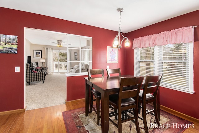 dining room with a ceiling fan, hardwood / wood-style flooring, and baseboards