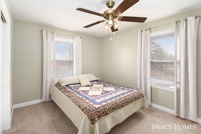 carpeted bedroom with ceiling fan and baseboards