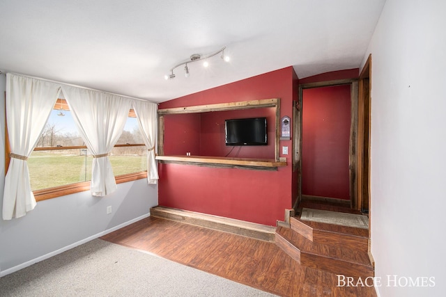 interior space with lofted ceiling, wood finished floors, and baseboards