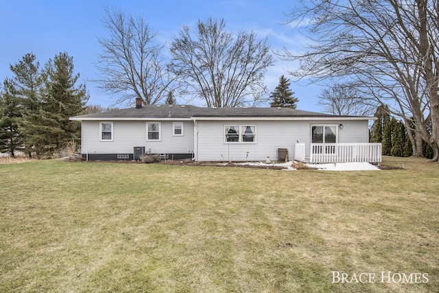 back of property with a yard, a chimney, and central air condition unit