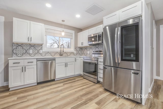 kitchen with stainless steel appliances, white cabinets, and a sink