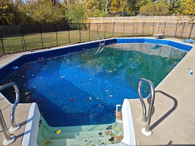 view of pool featuring a fenced in pool, a fenced backyard, a lawn, and a diving board