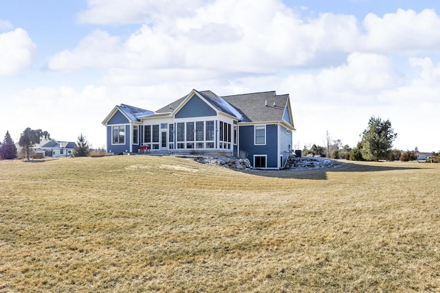 rear view of property with a yard and a sunroom