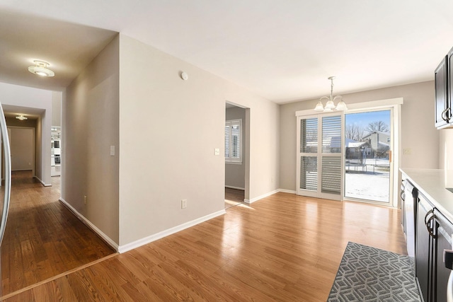 interior space featuring an inviting chandelier, hanging light fixtures, and light hardwood / wood-style flooring