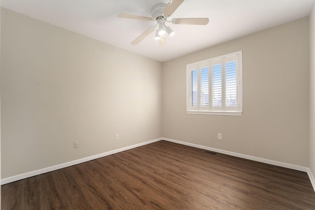 spare room with dark hardwood / wood-style floors and ceiling fan