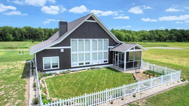 back of property with a yard and a sunroom