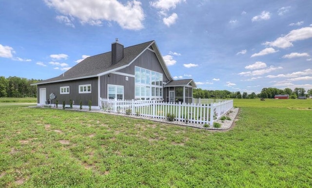 view of side of property with a sunroom and a lawn