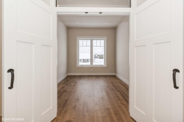 unfurnished room featuring baseboards and wood finished floors