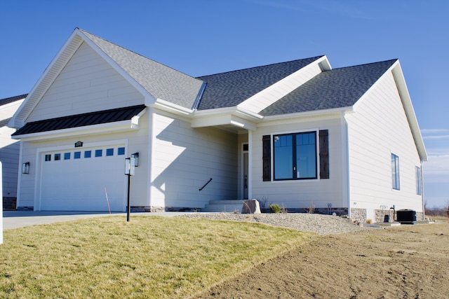 view of front of house with a garage, a shingled roof, central AC unit, metal roof, and a standing seam roof