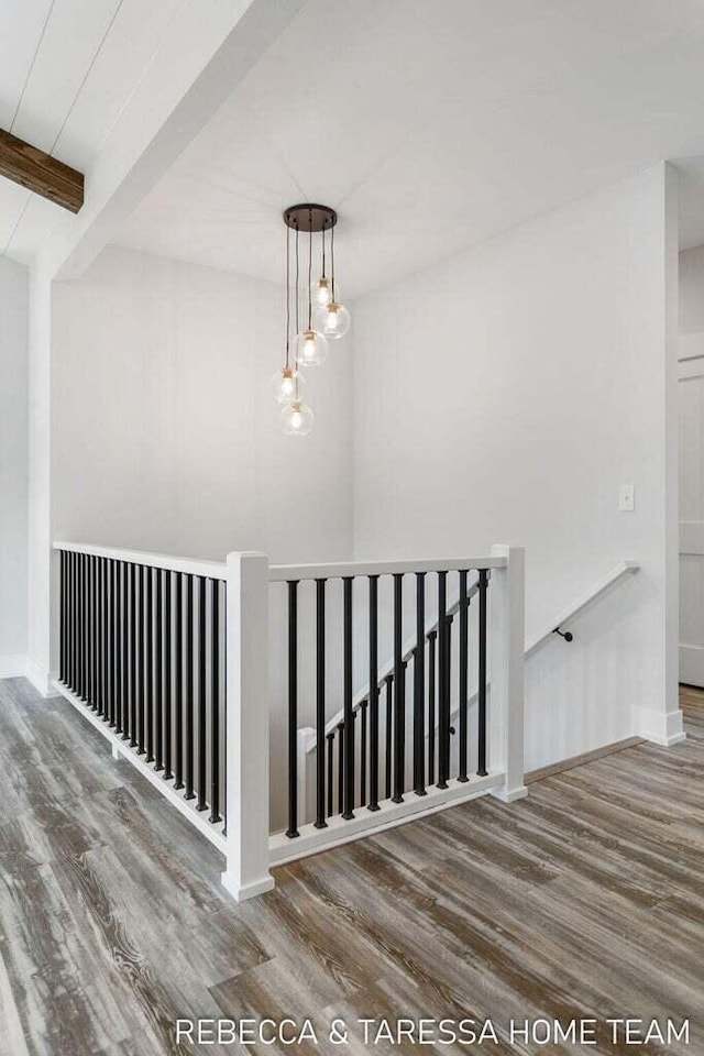 stairway with beam ceiling and hardwood / wood-style floors