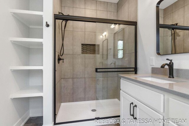 bathroom featuring vanity and a shower with door